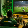 Three friends watching a football match on a large television